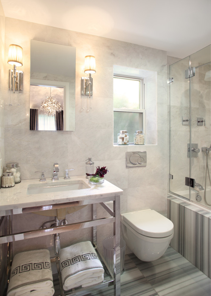ニューヨークにあるトランジショナルスタイルのおしゃれな浴室 (アンダーカウンター洗面器、アルコーブ型浴槽、シャワー付き浴槽	、壁掛け式トイレ、グレーのタイル) の写真
