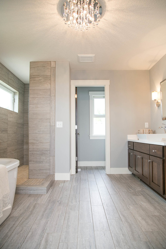 Inspiration pour une salle de bain principale design en bois foncé avec une vasque, un placard avec porte à panneau encastré, un plan de toilette en marbre, une baignoire indépendante, une douche ouverte, WC séparés, un carrelage gris, des carreaux de céramique et un mur gris.