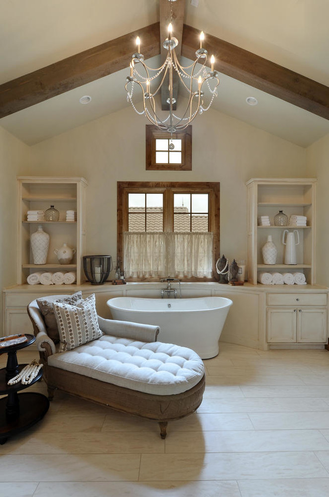 Cette photo montre une salle de bain chic avec des portes de placard beiges, une baignoire indépendante, un carrelage beige et un mur beige.