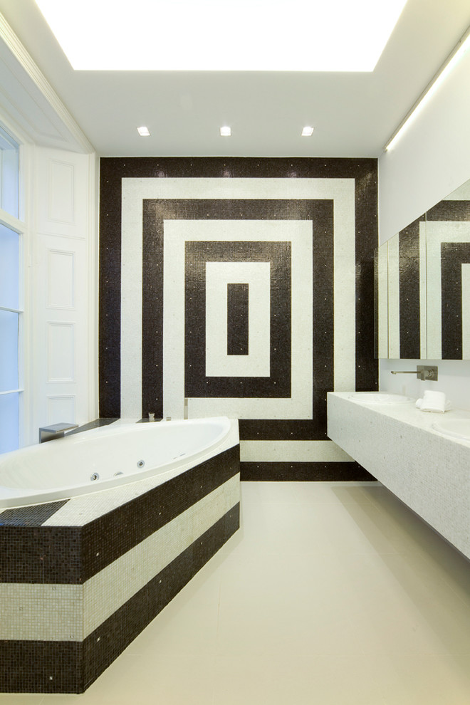 Réalisation d'une salle de bain design avec un carrelage noir et blanc et du carrelage bicolore.