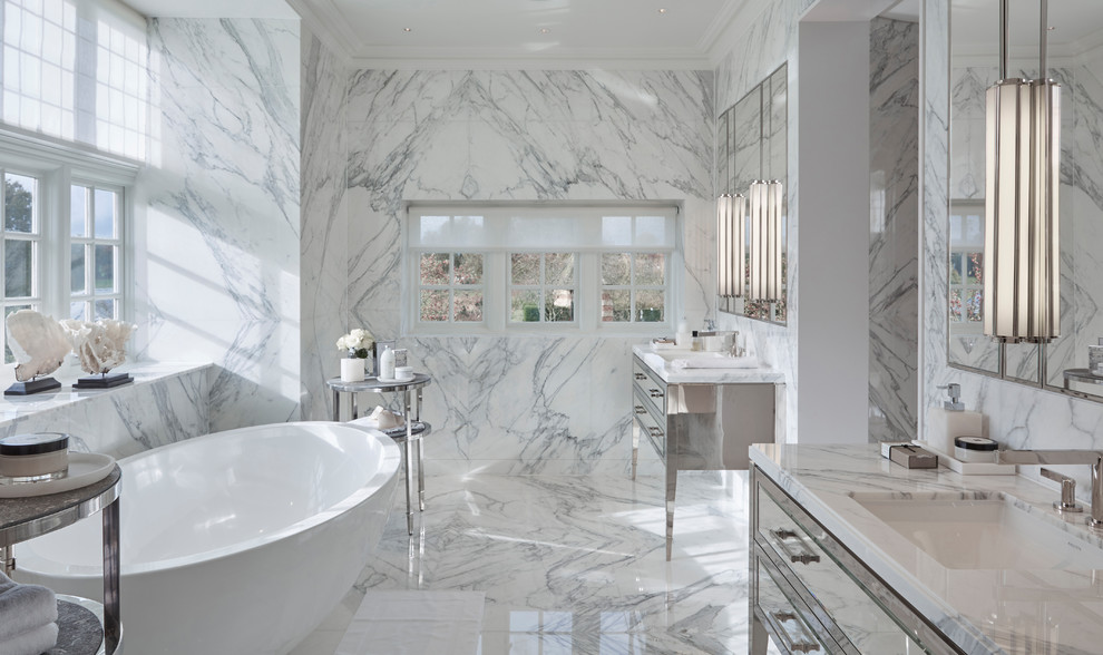 Стильный дизайн: главная ванная комната в современном стиле с отдельно стоящей ванной, белой плиткой, мраморной плиткой, белыми стенами, мраморным полом, врезной раковиной, белым полом, зеркалом с подсветкой и плоскими фасадами - последний тренд