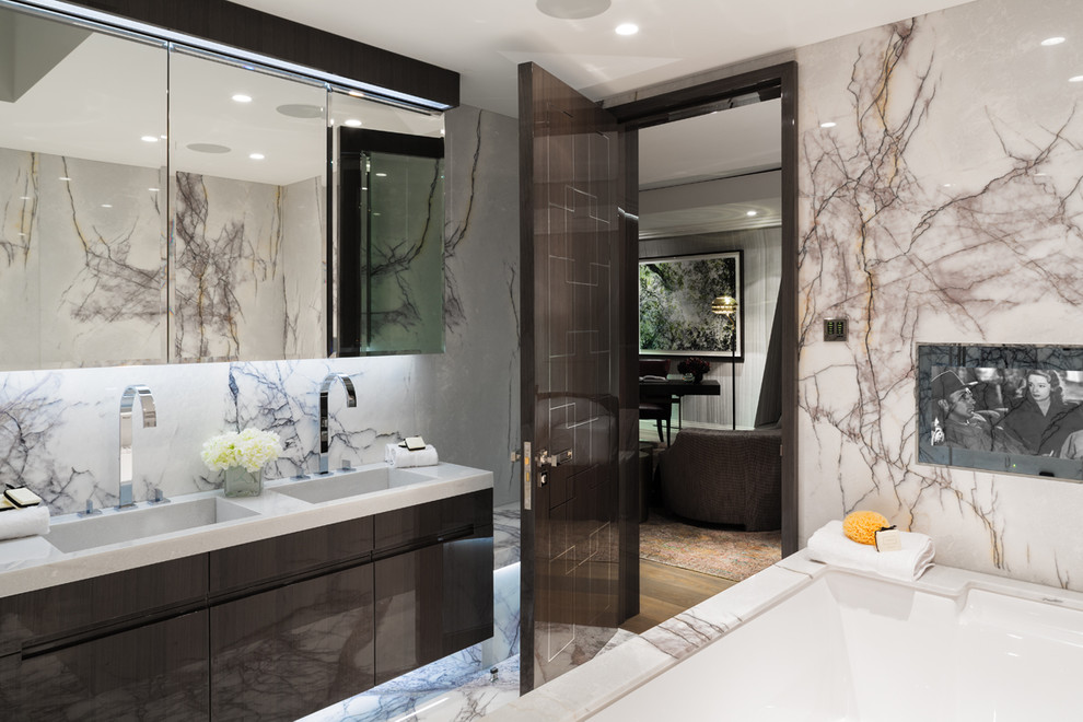 На фото: главная ванная комната в современном стиле с плоскими фасадами, коричневыми фасадами, полновстраиваемой ванной, бежевыми стенами, мраморным полом и монолитной раковиной с