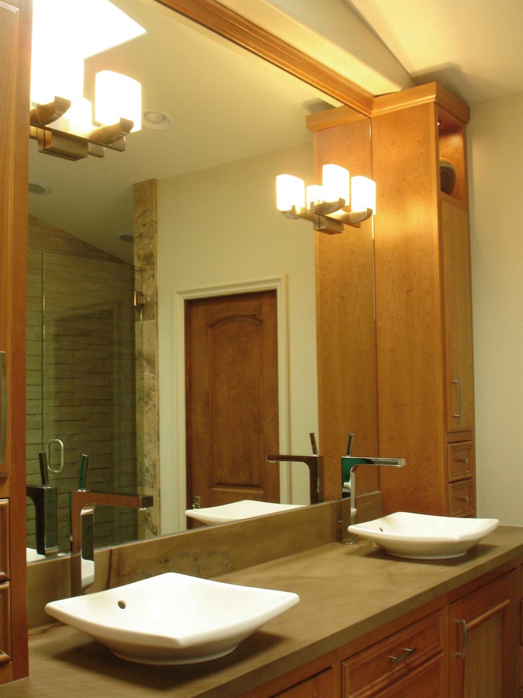 Inredning av ett modernt en-suite badrum, med luckor med infälld panel, skåp i mellenmörkt trä, ett fristående badkar, en dusch i en alkov, en toalettstol med hel cisternkåpa, beige kakel, beige väggar, ett fristående handfat, bänkskiva i täljsten och dusch med gångjärnsdörr