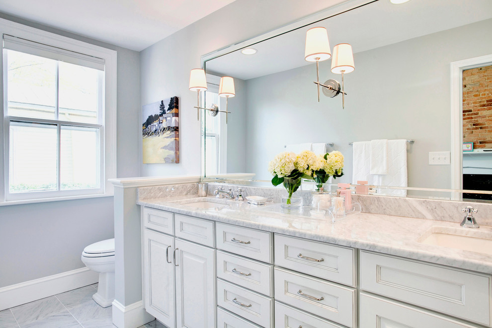 Imagen de cuarto de baño principal tradicional grande con lavabo bajoencimera, armarios con paneles empotrados, puertas de armario blancas y paredes grises