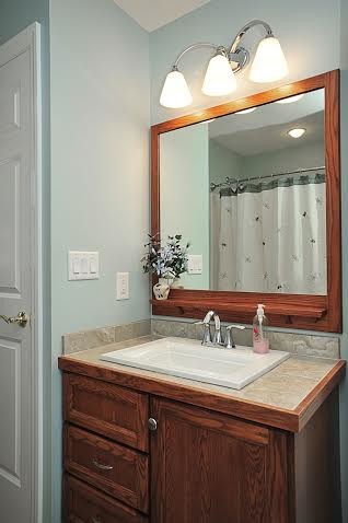 Inredning av ett amerikanskt mellanstort en-suite badrum, med luckor med infälld panel, skåp i mellenmörkt trä, ett hörnbadkar, en toalettstol med separat cisternkåpa, gröna väggar och ett nedsänkt handfat