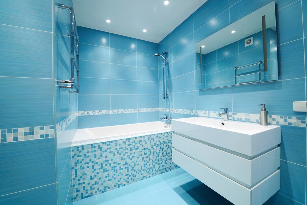 Foto di una stanza da bagno padronale di medie dimensioni con lavabo rettangolare, vasca/doccia, piastrelle blu, piastrelle in ceramica, pareti blu e pavimento con piastrelle in ceramica