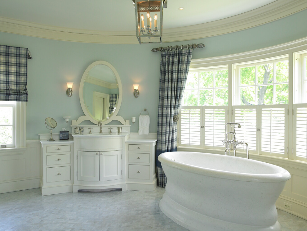 Imagen de cuarto de baño principal actual de tamaño medio con armarios con paneles lisos, bañera exenta, baldosas y/o azulejos azules y paredes azules