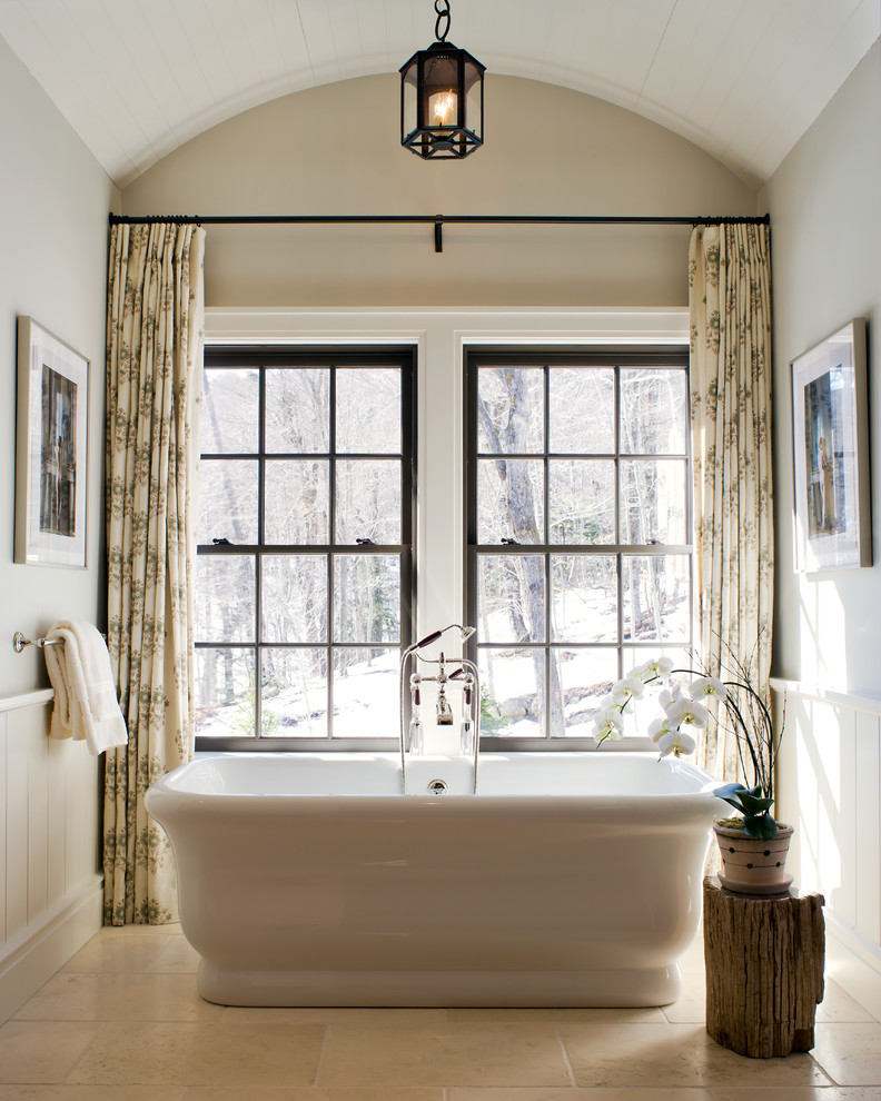 Ejemplo de cuarto de baño rectangular tradicional con bañera exenta y paredes beige