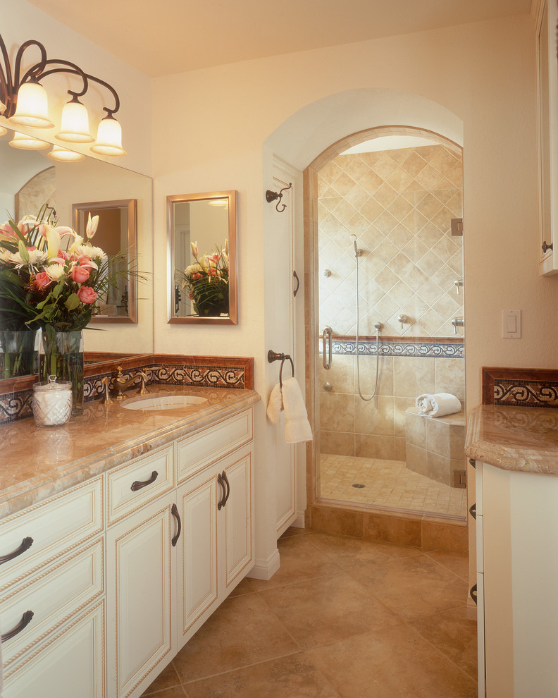 Inspiration för moderna badrum, med ett undermonterad handfat, luckor med upphöjd panel, beige skåp, en dusch i en alkov, beige kakel och travertinkakel