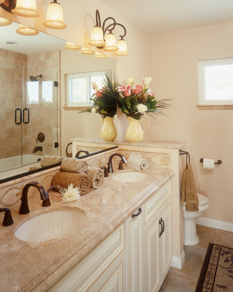 Idéer för ett klassiskt badrum, med ett undermonterad handfat, luckor med upphöjd panel, vita skåp och beige kakel