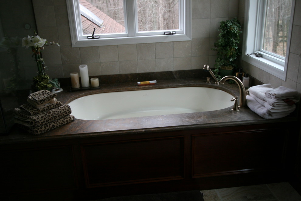Immagine di una stanza da bagno padronale stile shabby di medie dimensioni con ante lisce, ante in legno bruno, top in granito, vasca da incasso, piastrelle grigie, piastrelle in pietra e pareti beige