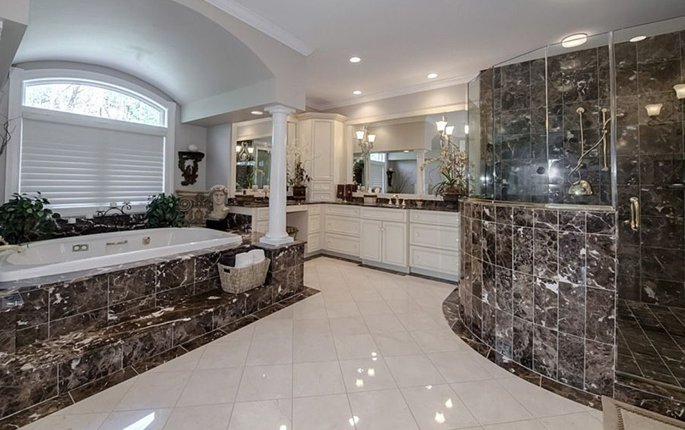 Exempel på ett mycket stort klassiskt en-suite badrum, med ett undermonterad handfat, luckor med infälld panel, beige skåp, marmorbänkskiva, ett platsbyggt badkar, en dubbeldusch, en bidé, flerfärgad kakel, stenhäll, beige väggar, marmorgolv, vitt golv och dusch med gångjärnsdörr