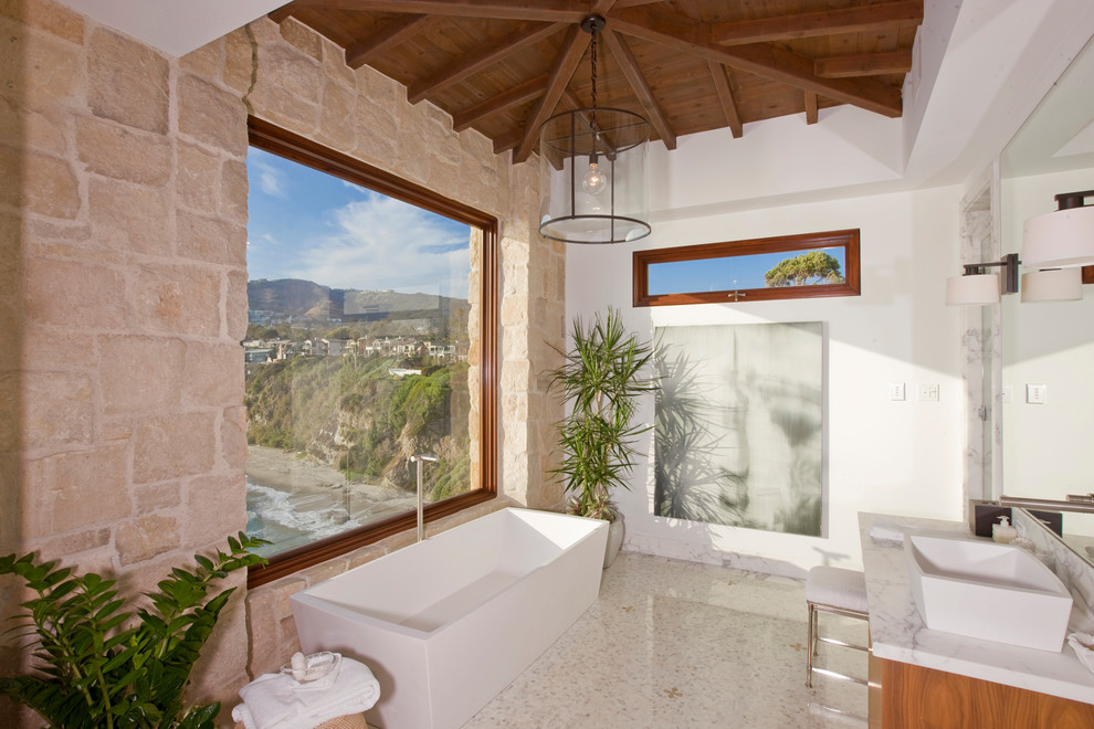 Стильный дизайн: ванная комната в средиземноморском стиле с настольной раковиной и плиткой из известняка - последний тренд