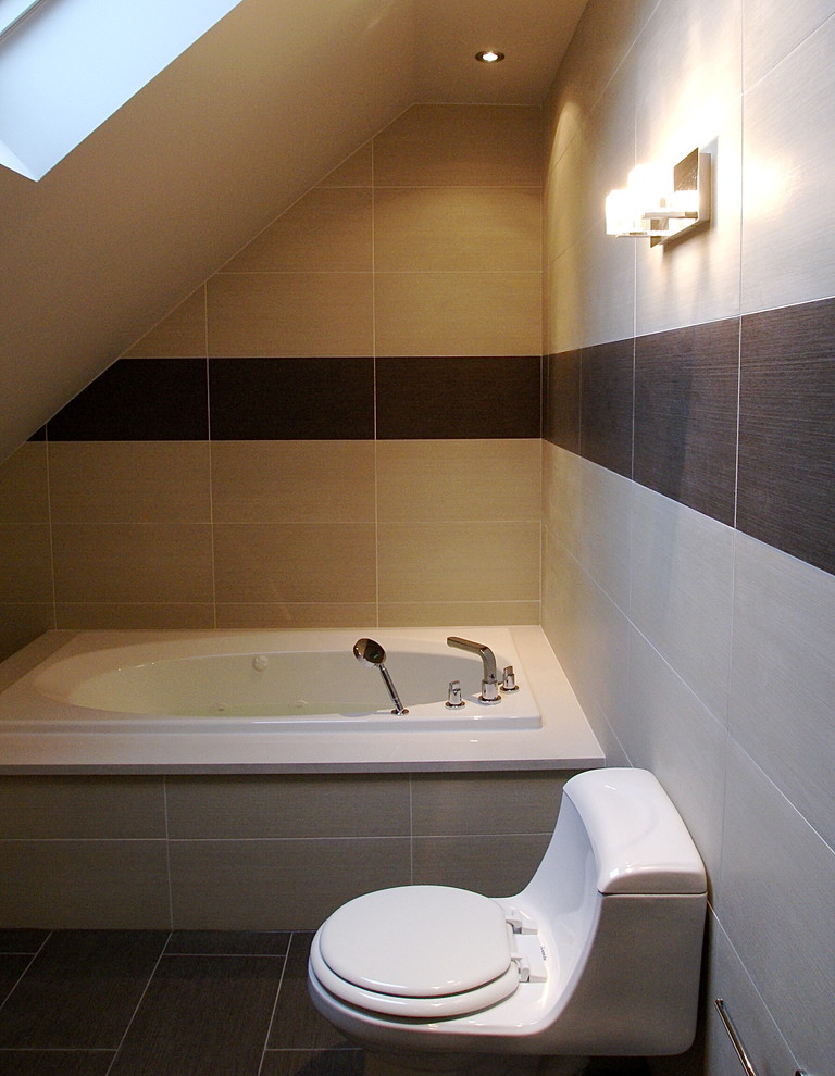 Ejemplo de cuarto de baño moderno con bañera encastrada, sanitario de una pieza y baldosas y/o azulejos grises