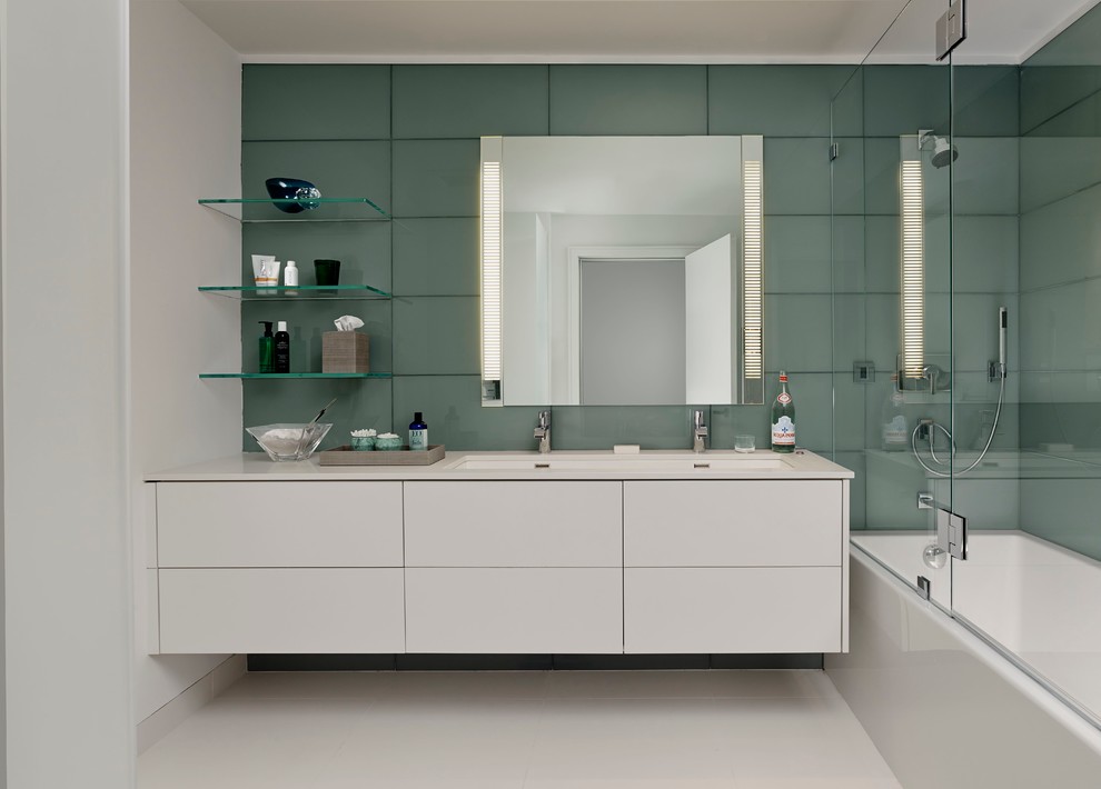 Bild på ett mellanstort funkis en-suite badrum, med släta luckor, vita skåp, ett badkar i en alkov, en dusch/badkar-kombination, grön kakel, keramikplattor, gröna väggar, klinkergolv i porslin, ett undermonterad handfat och bänkskiva i akrylsten