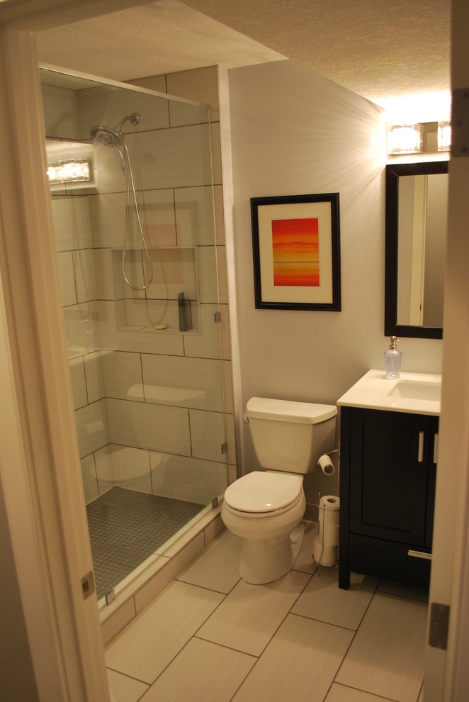 На фото: маленькая ванная комната в стиле модернизм с фасадами в стиле шейкер, темными деревянными фасадами, душем в нише, раздельным унитазом, бежевой плиткой, керамогранитной плиткой, бежевыми стенами, полом из ламината, душевой кабиной, врезной раковиной, столешницей из искусственного камня, бежевым полом и душем с распашными дверями для на участке и в саду