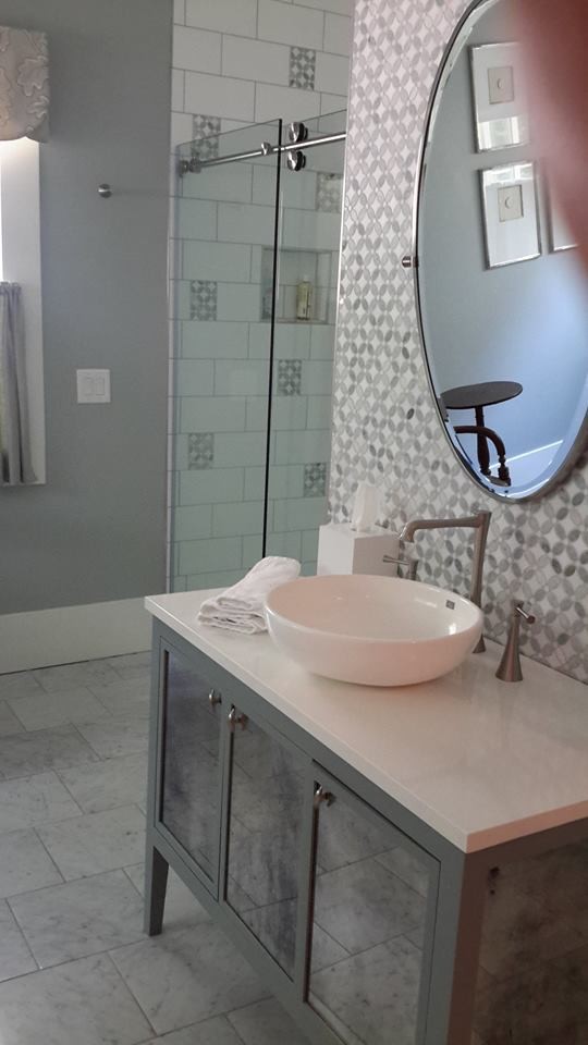 На фото: ванная комната среднего размера в современном стиле с стеклянными фасадами, серыми фасадами, угловым душем, плиткой мозаикой, серыми стенами, мраморным полом, настольной раковиной, столешницей из известняка, белым полом и душем с распашными дверями