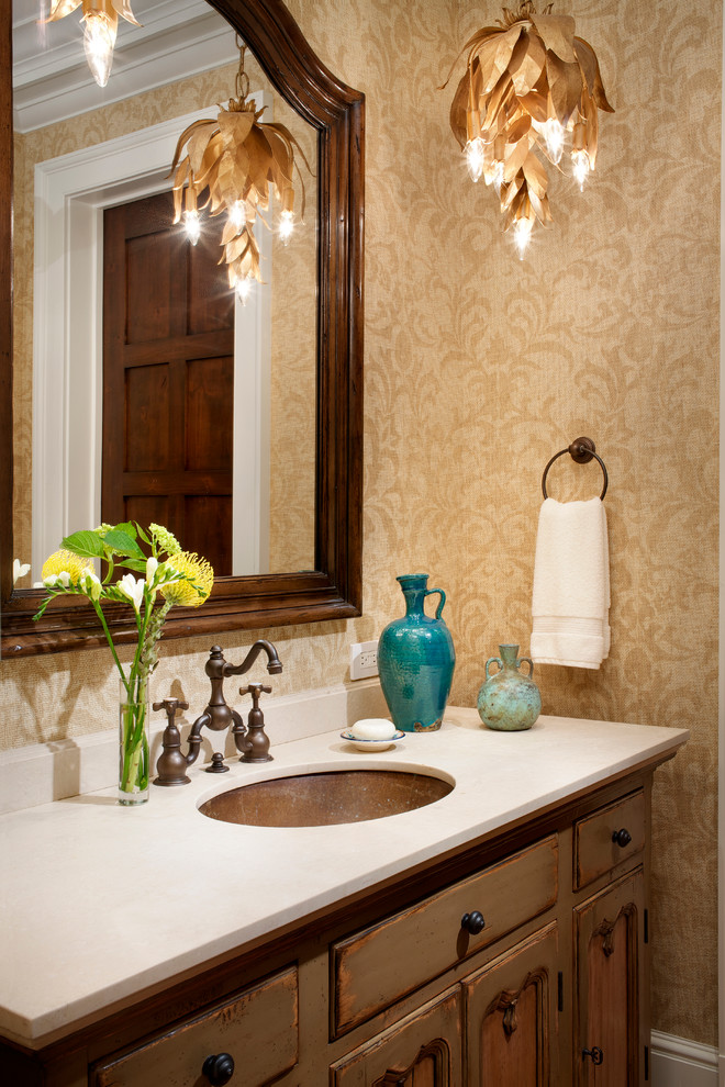 На фото: ванная комната в классическом стиле с врезной раковиной, искусственно-состаренными фасадами и бежевыми стенами