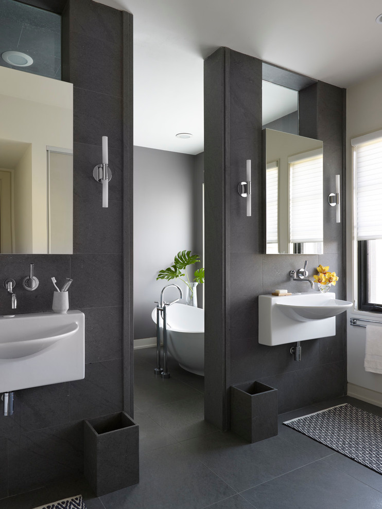 Trendy gray tile freestanding bathtub photo in Chicago with a wall-mount sink and gray walls