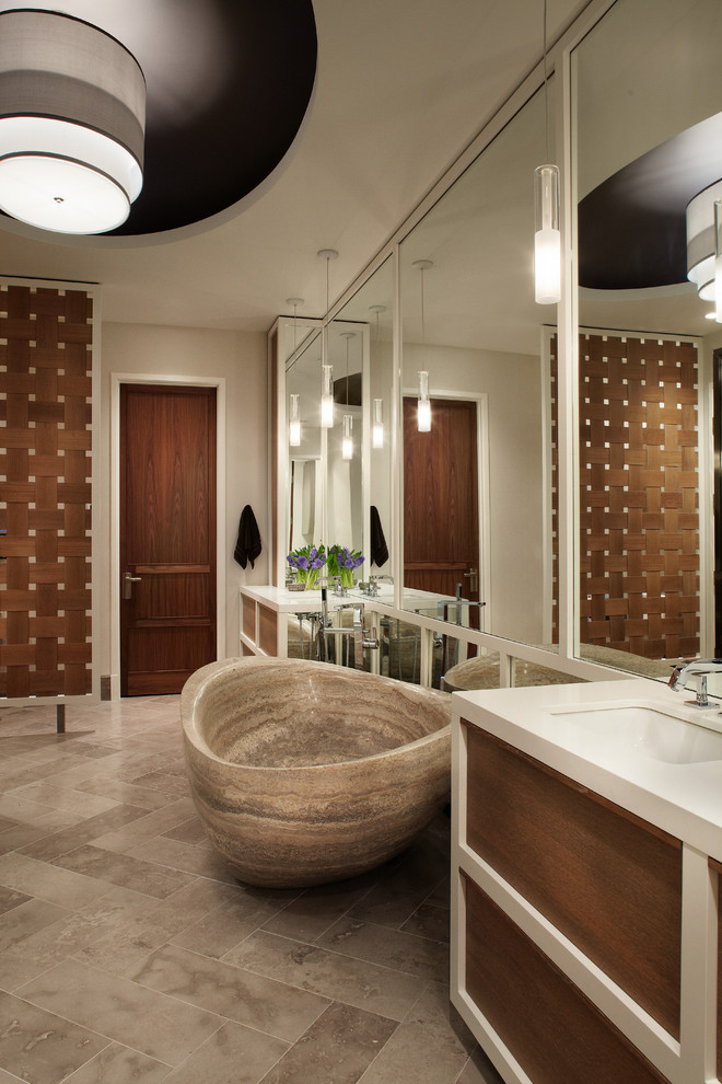 Ejemplo de cuarto de baño contemporáneo con lavabo bajoencimera, armarios con paneles lisos, puertas de armario de madera oscura, bañera exenta y paredes beige