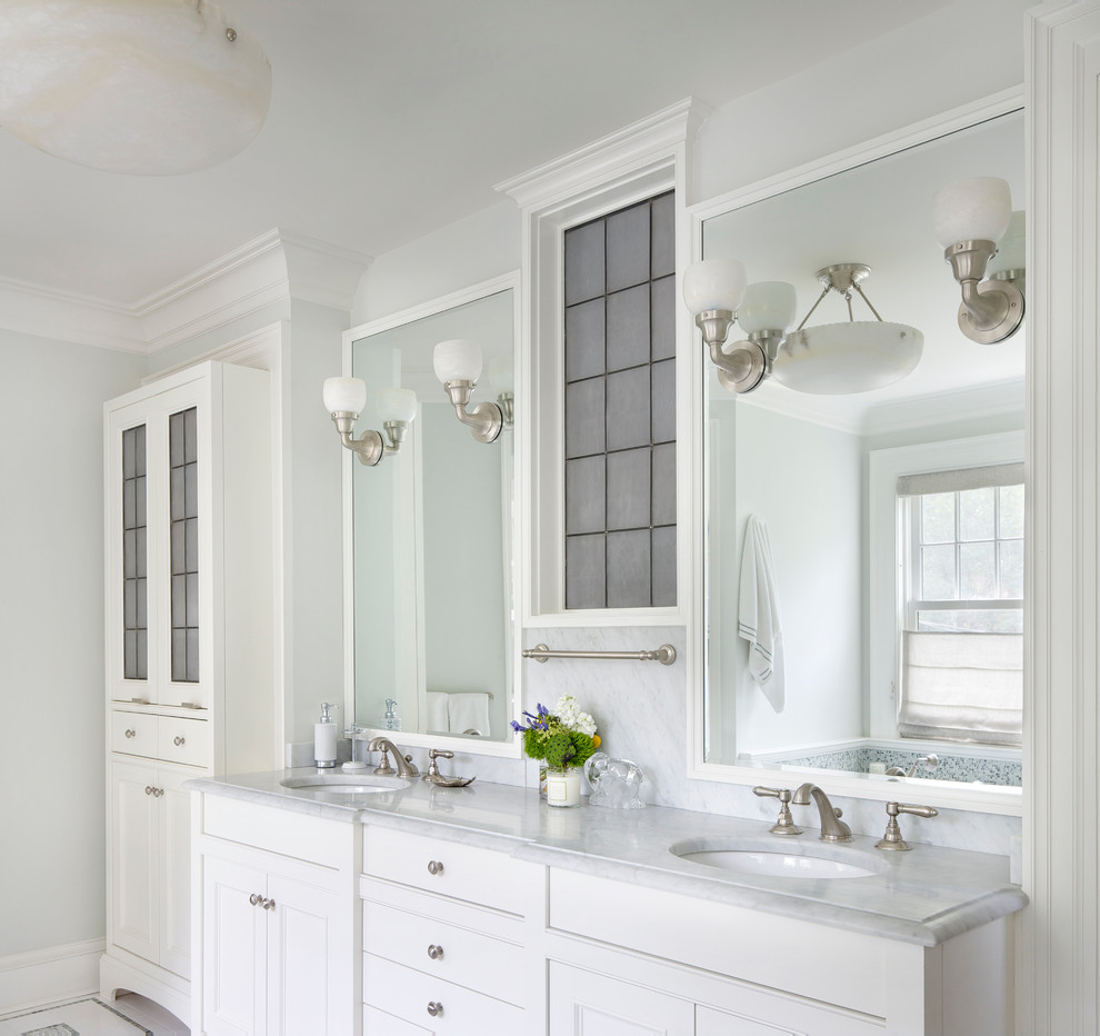 Foto de cuarto de baño clásico con lavabo bajoencimera, armarios con paneles empotrados, puertas de armario blancas y paredes grises