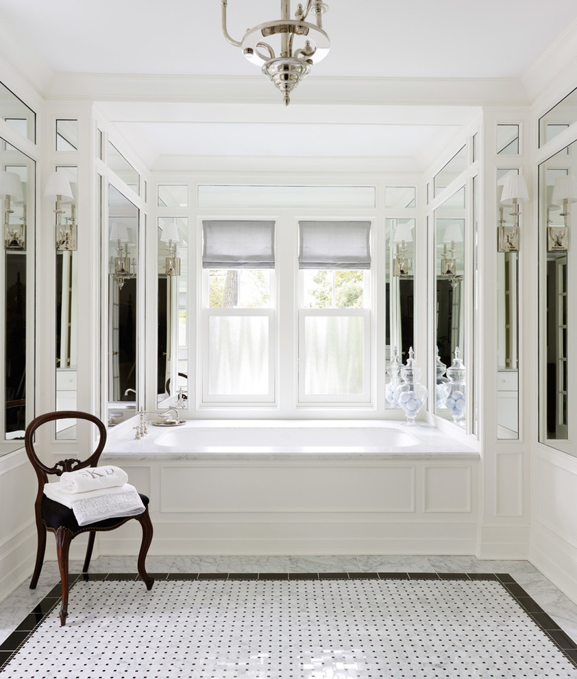 Elegant bathroom photo in Chicago with an undermount tub and white walls
