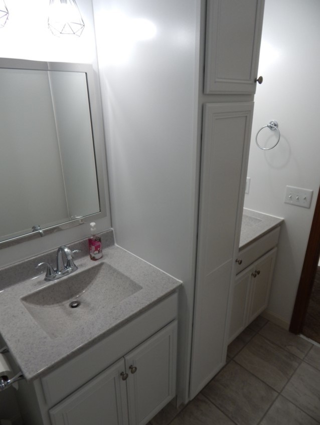 Cette image montre une salle de bain principale traditionnelle de taille moyenne avec un placard avec porte à panneau encastré, des portes de placard blanches, une baignoire en alcôve, WC séparés, un carrelage gris, des carreaux de porcelaine, un mur beige, un sol en carrelage de porcelaine, un lavabo intégré, un plan de toilette en stratifié, un sol gris et un plan de toilette gris.