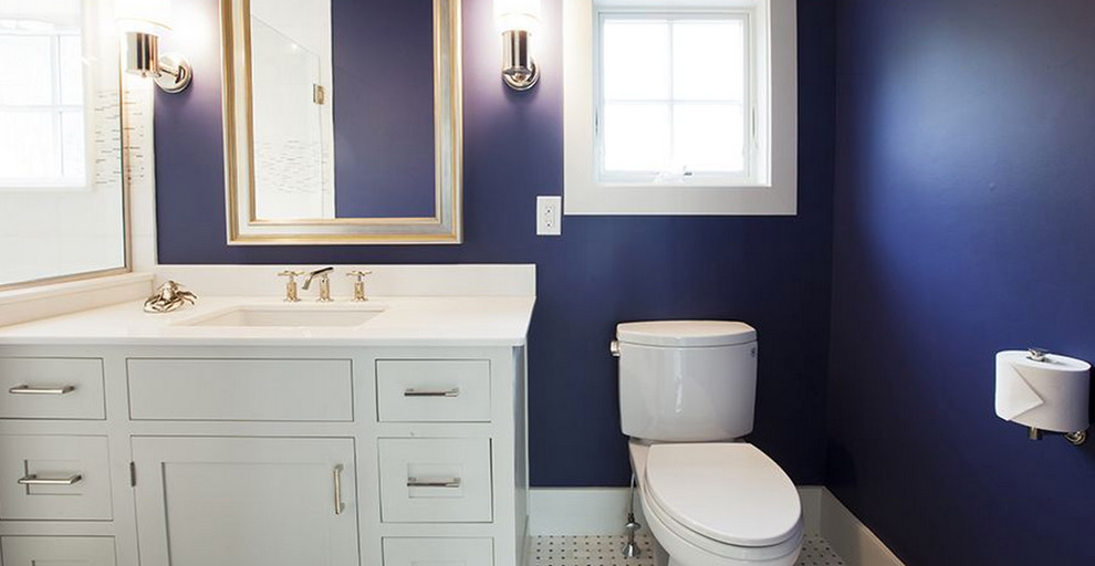 Idee per una stanza da bagno con doccia stile marino di medie dimensioni con ante in stile shaker, ante bianche, WC a due pezzi, pareti blu, pavimento in gres porcellanato, lavabo sottopiano e top in superficie solida