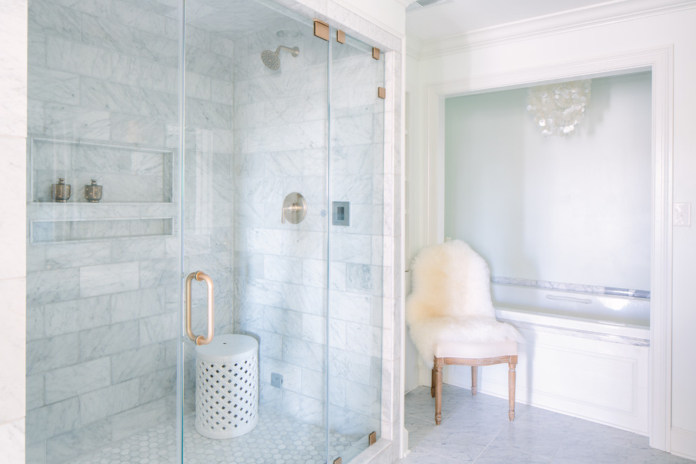 Modelo de cuarto de baño clásico con lavabo encastrado, puertas de armario grises, encimera de mármol, bañera encastrada, ducha doble, sanitario de dos piezas y baldosas y/o azulejos de piedra