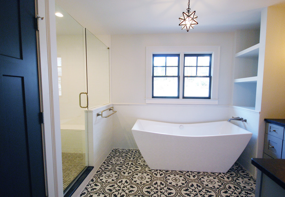 Modelo de cuarto de baño de estilo de casa de campo con puertas de armario grises, bañera exenta, baldosas y/o azulejos blancos, baldosas y/o azulejos de cemento, paredes blancas y suelo de azulejos de cemento
