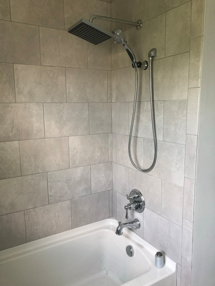 Immagine di una stanza da bagno tradizionale con vasca/doccia, vasca ad alcova, piastrelle beige, piastrelle in pietra e doccia aperta
