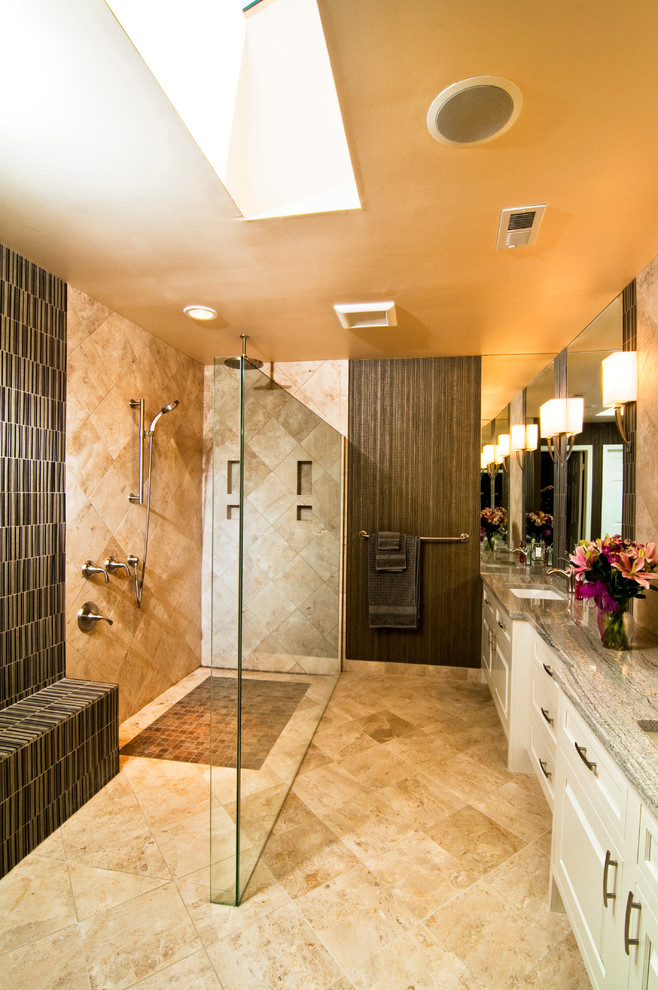 Bild på ett funkis badrum, med ett undermonterad handfat, vita skåp, en kantlös dusch och beige kakel