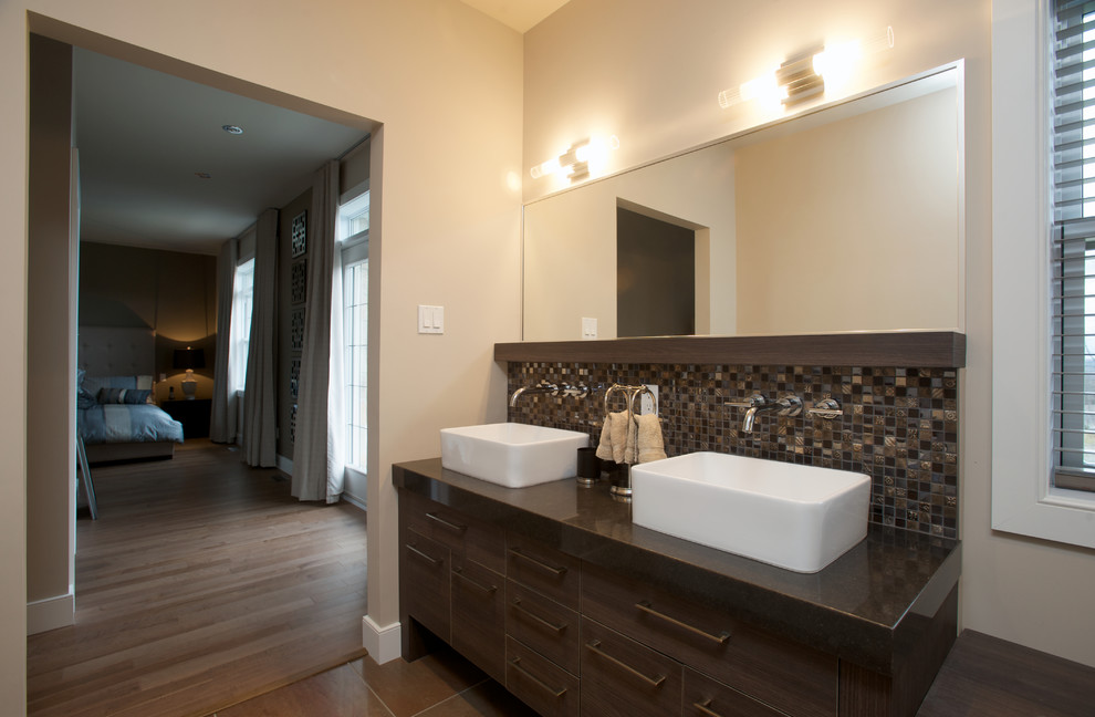 Inspiration for a large ensuite bathroom in Montreal with a vessel sink, flat-panel cabinets, dark wood cabinets, quartz worktops, a built-in bath, a one-piece toilet, beige walls and ceramic flooring.