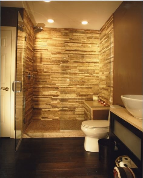 Bild på ett stort funkis en-suite badrum, med släta luckor, svarta skåp, en dusch i en alkov, en toalettstol med hel cisternkåpa, bruna väggar, mörkt trägolv och ett fristående handfat