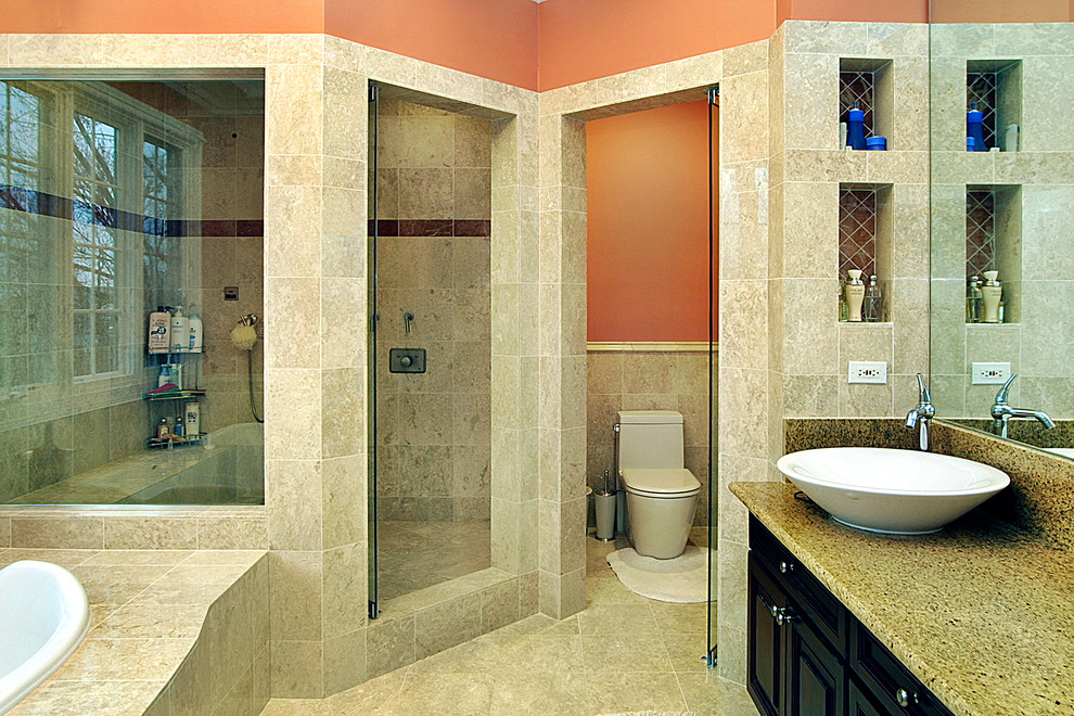Idée de décoration pour une douche en alcôve principale tradition de taille moyenne avec une vasque, un placard avec porte à panneau surélevé, un plan de toilette en granite, une baignoire posée, WC à poser, un carrelage beige, un carrelage de pierre, un mur orange et un sol en travertin.
