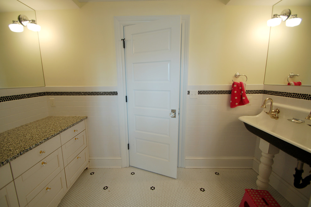 Cette photo montre une petite salle de bain chic pour enfant avec un lavabo suspendu, un placard avec porte à panneau encastré, des portes de placard blanches, un plan de toilette en granite, un carrelage blanc, un carrelage métro, un mur jaune et un sol en galet.