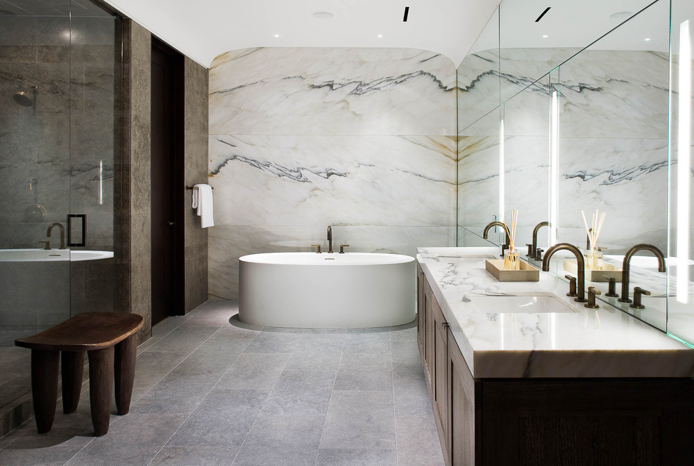 Modern inredning av ett badrum, med en dusch i en alkov, marmorbänkskiva och marmorkakel