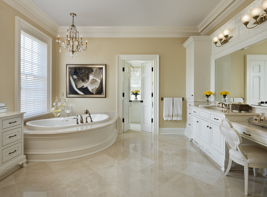 Пример оригинального дизайна: большая главная ванная комната в классическом стиле с фасадами с выступающей филенкой, белыми фасадами, гидромассажной ванной, бежевыми стенами, мраморным полом, врезной раковиной, бежевым полом и бежевой столешницей