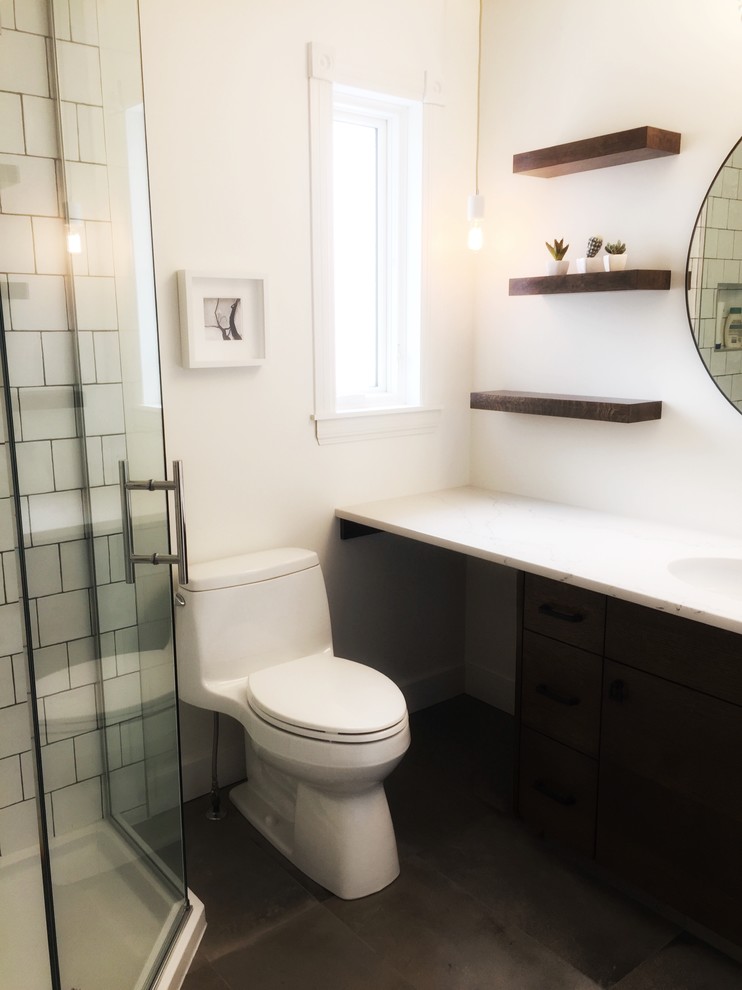 Small traditional ensuite bathroom in Edmonton with flat-panel cabinets, brown cabinets, a corner shower, a one-piece toilet, white tiles, ceramic tiles, white walls, porcelain flooring, a submerged sink, quartz worktops, grey floors and a hinged door.