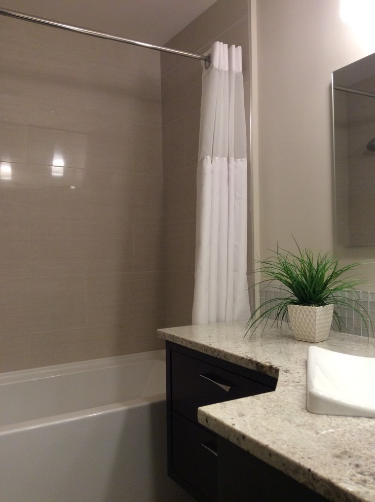 Inredning av ett klassiskt litet en-suite badrum, med släta luckor, skåp i mörkt trä, ett badkar i en alkov, en dusch/badkar-kombination, en toalettstol med hel cisternkåpa, vit kakel, porslinskakel, beige väggar, klinkergolv i porslin, ett nedsänkt handfat, granitbänkskiva, grått golv och dusch med duschdraperi