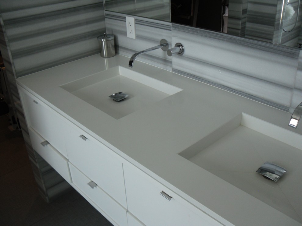 Foto de cuarto de baño principal contemporáneo de tamaño medio con lavabo integrado, encimera de acrílico y paredes grises