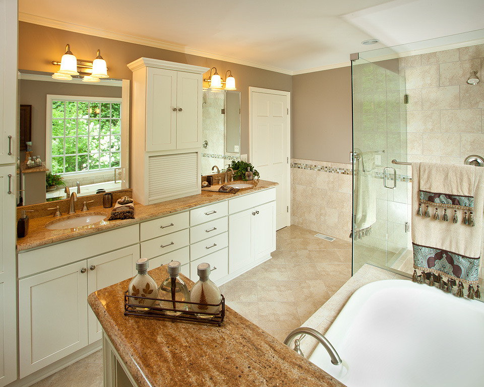 Example of a large transitional master beige tile and porcelain tile porcelain tile and beige floor bathroom design in Raleigh with an undermount sink, shaker cabinets, white cabinets, granite countertops, a two-piece toilet, brown walls, a hinged shower door and brown countertops