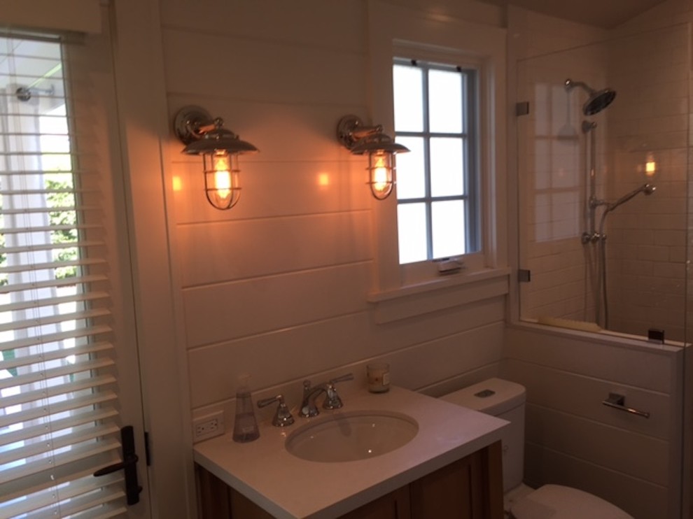 Inspiration pour une salle d'eau rustique en bois brun de taille moyenne avec un placard à porte shaker, une douche d'angle, WC à poser, un carrelage blanc, des carreaux de céramique, un mur blanc, un lavabo posé et un plan de toilette en surface solide.