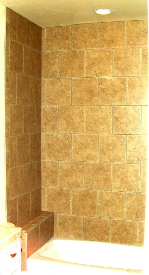 Inredning av ett badrum, med luckor med upphöjd panel, skåp i mörkt trä, kaklad bänkskiva, beige väggar och klinkergolv i keramik