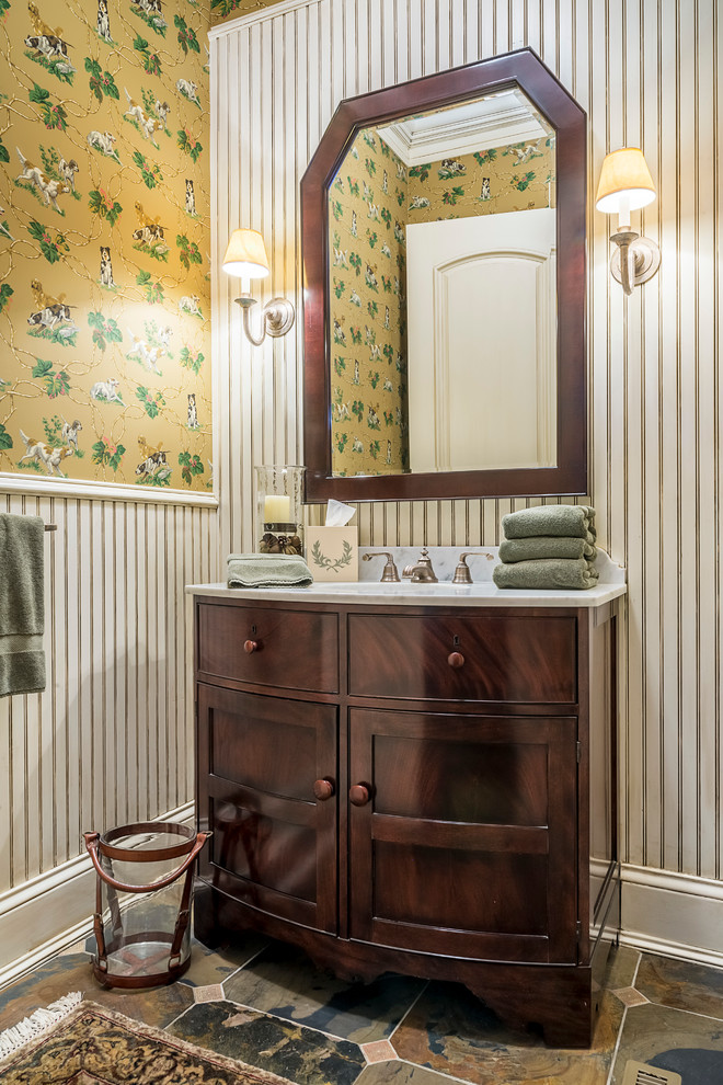 Imagen de cuarto de baño tradicional pequeño con puertas de armario de madera en tonos medios, suelo de travertino, encimera de mármol, paredes amarillas y armarios estilo shaker
