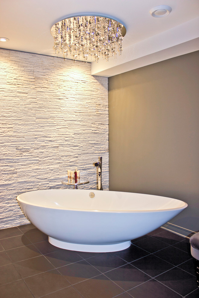Cette image montre une grande salle de bain principale minimaliste en bois foncé avec une vasque, un placard à porte plane, une baignoire indépendante, un carrelage blanc, des dalles de pierre, un mur gris et un sol en ardoise.