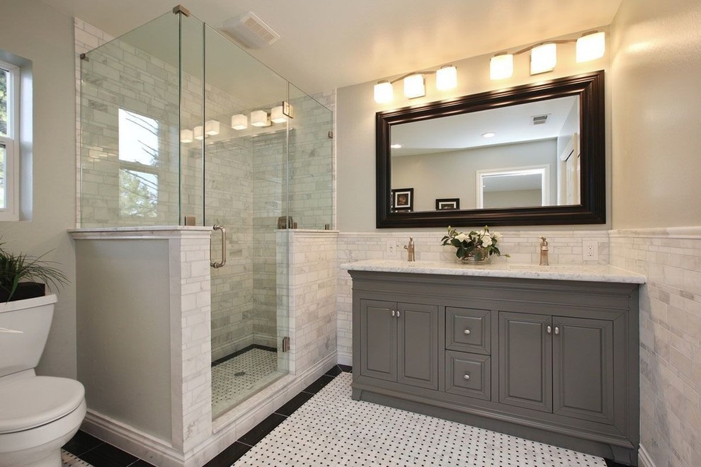 Exempel på ett mellanstort klassiskt badrum med dusch, med luckor med upphöjd panel, grå skåp, en dusch i en alkov, en toalettstol med hel cisternkåpa, grå kakel, stenkakel, vita väggar, marmorgolv, ett undermonterad handfat och marmorbänkskiva