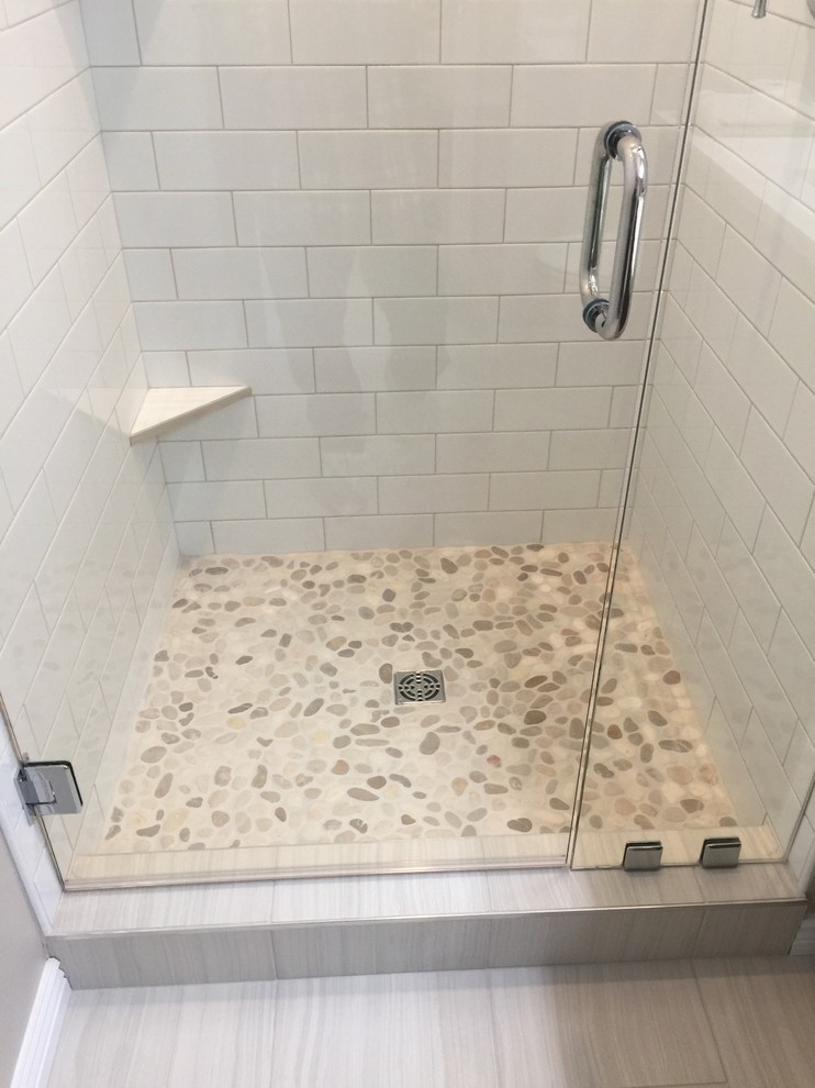 This is an example of a small contemporary shower room bathroom in Boise with shaker cabinets, brown cabinets, a corner shower, a two-piece toilet, white tiles, metro tiles, beige walls, porcelain flooring, a submerged sink, quartz worktops, grey floors, a hinged door and white worktops.