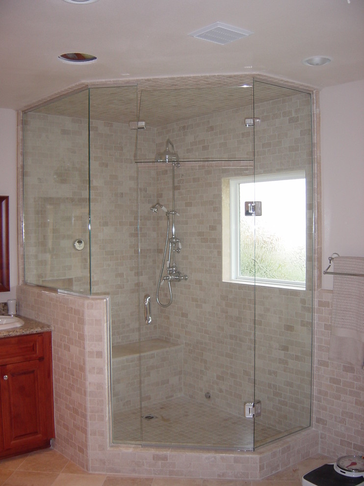 Example of a mid-sized classic master gray tile and glass sheet travertine floor bathroom design in Orange County with raised-panel cabinets, medium tone wood cabinets, a two-piece toilet, white walls, a drop-in sink and granite countertops