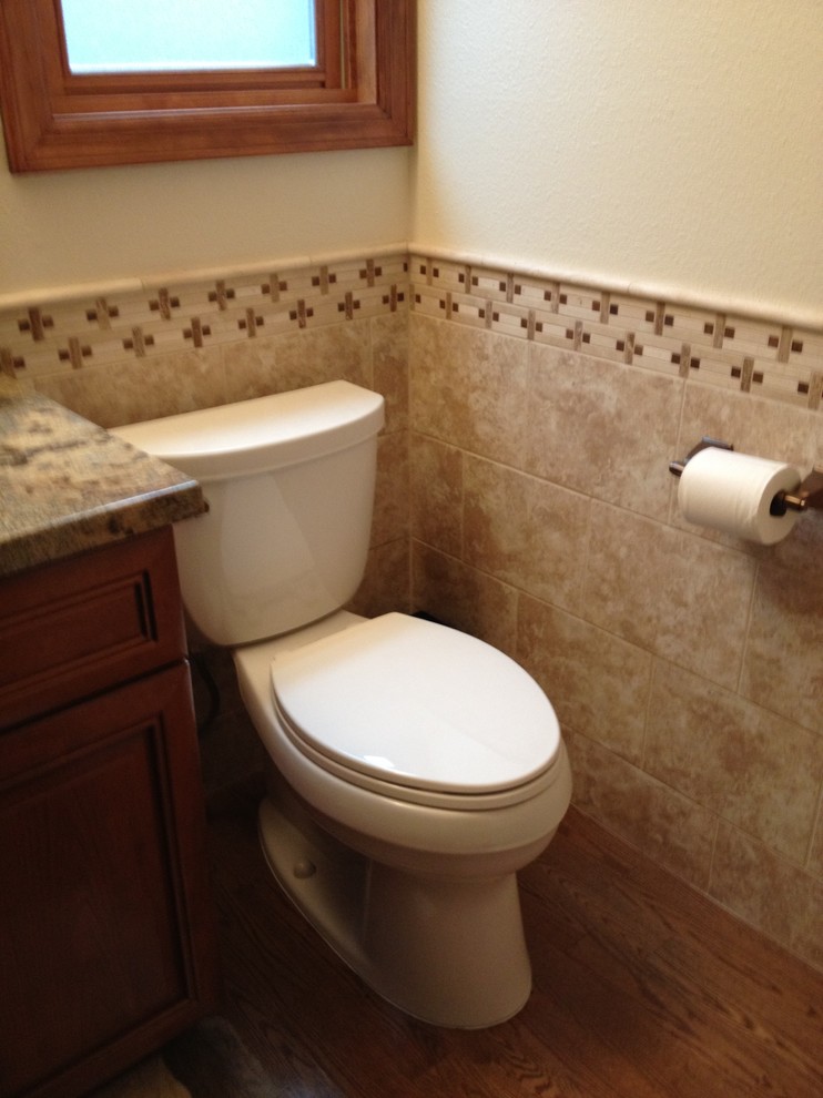 Inspiration för mellanstora klassiska toaletter, med luckor med upphöjd panel, skåp i mellenmörkt trä, en toalettstol med separat cisternkåpa, beige väggar, travertin golv och granitbänkskiva